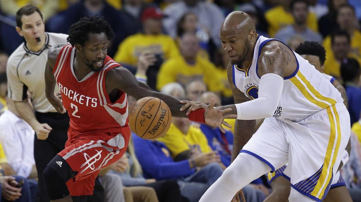 Marreese Speights, right, of the Warriors gets a handful of Patrick Beverly of the Rockets on Wednesday, April 27, 2016 in Oakland.
