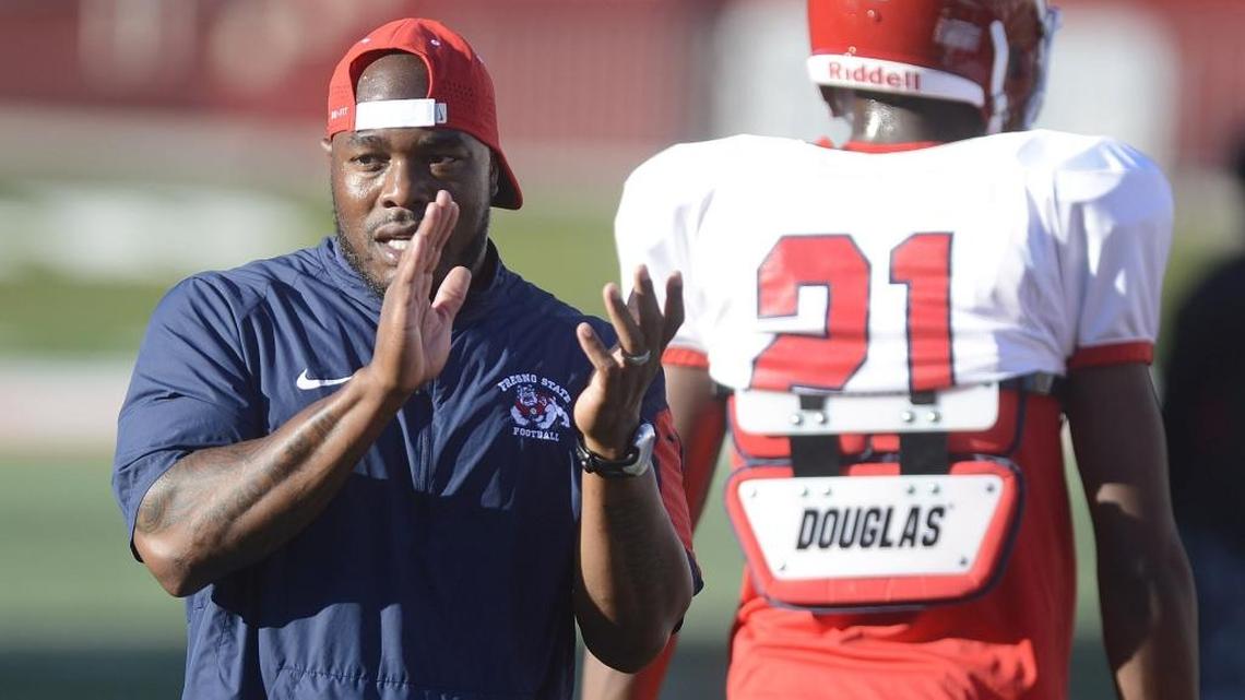 Fresno State assistant Ricky Manning Jr. encourages players during warm-ups before an August 2015 scrimmage at Bulldog Stadium. After one season with the Bulldogs, Manning’s next stop will be in the NFL as assistant secondary/cornerbacks coach under Seattle’s Pete Carroll.