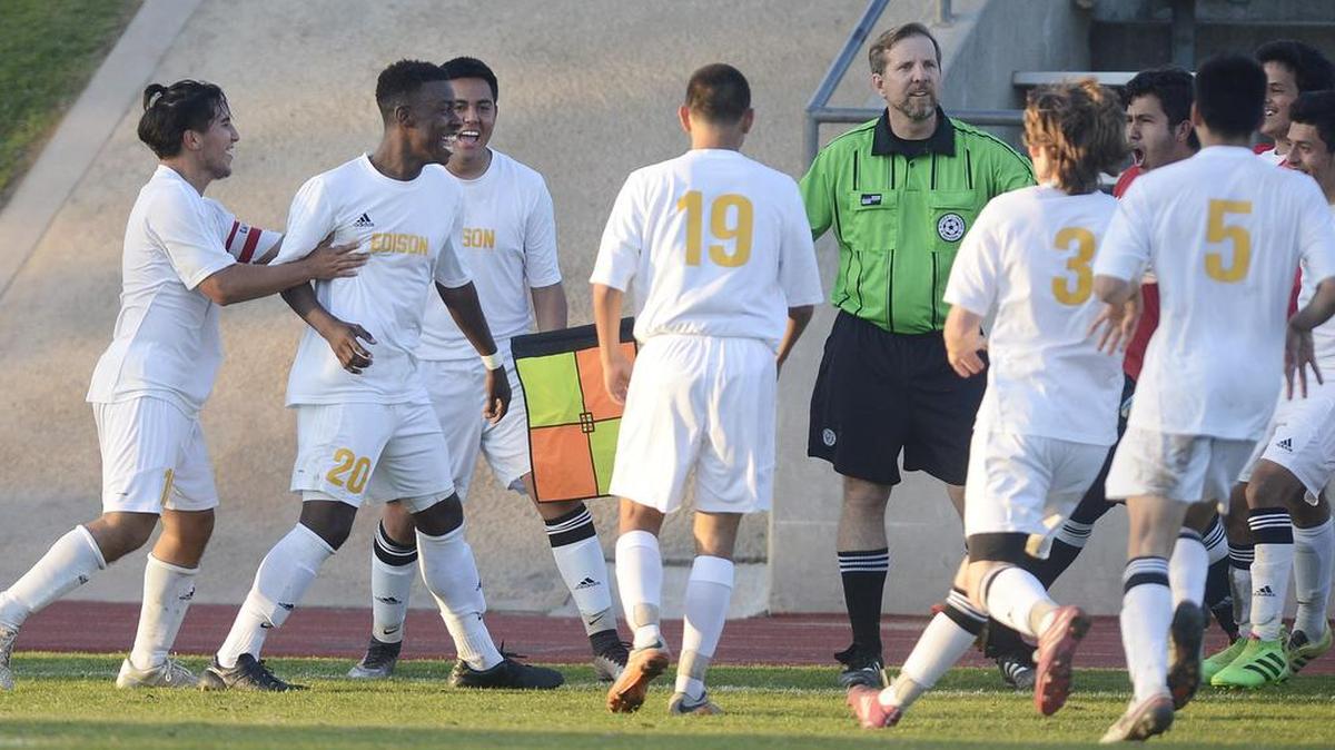 Edison's Michael Miller, second from left, celebrates his overtime goal against Golden West with teammates during their semifinal playoff game at McLane Stadium on Tuesday, Feb. 23, 2016.