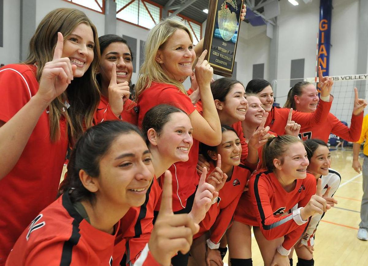 The Kerman volleyball team celebrates its win over Mammoth at the CIF Central Section girls volleyball championships Saturday at College of the Sequoias.