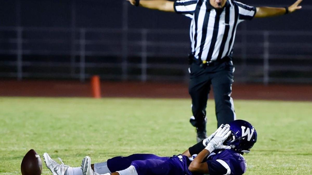 Washington’s Jesus Garcia covers his face after nearly intercepting a Memorial pass Friday night in Easton. Memorial won the season opener 21-14.