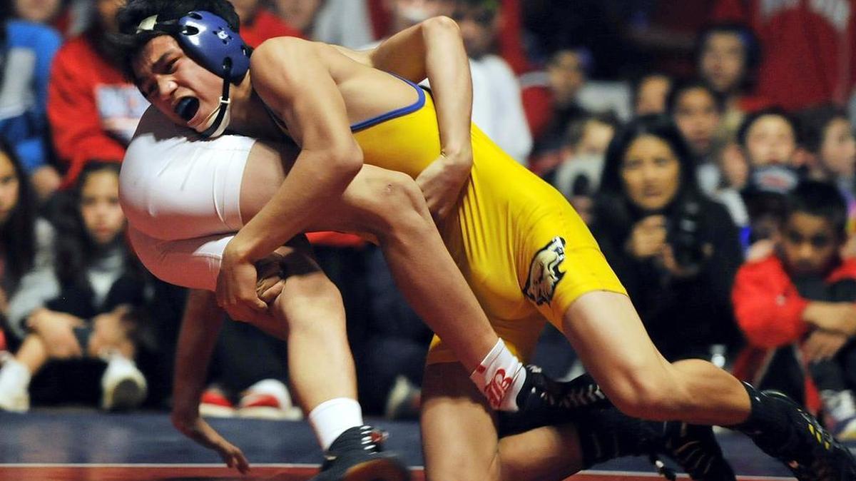 An overflow crowd of 2,500 watched Clovis’s Justin Mejia, top, take on Buchanan’s Chris Gaxiola in the 115-pound weight class last year during a Tri-River Athletic Conference dual meet. Another crowd of around 2,500 is expected when the Cougars and Bears clash again Thursday at Clovis.
