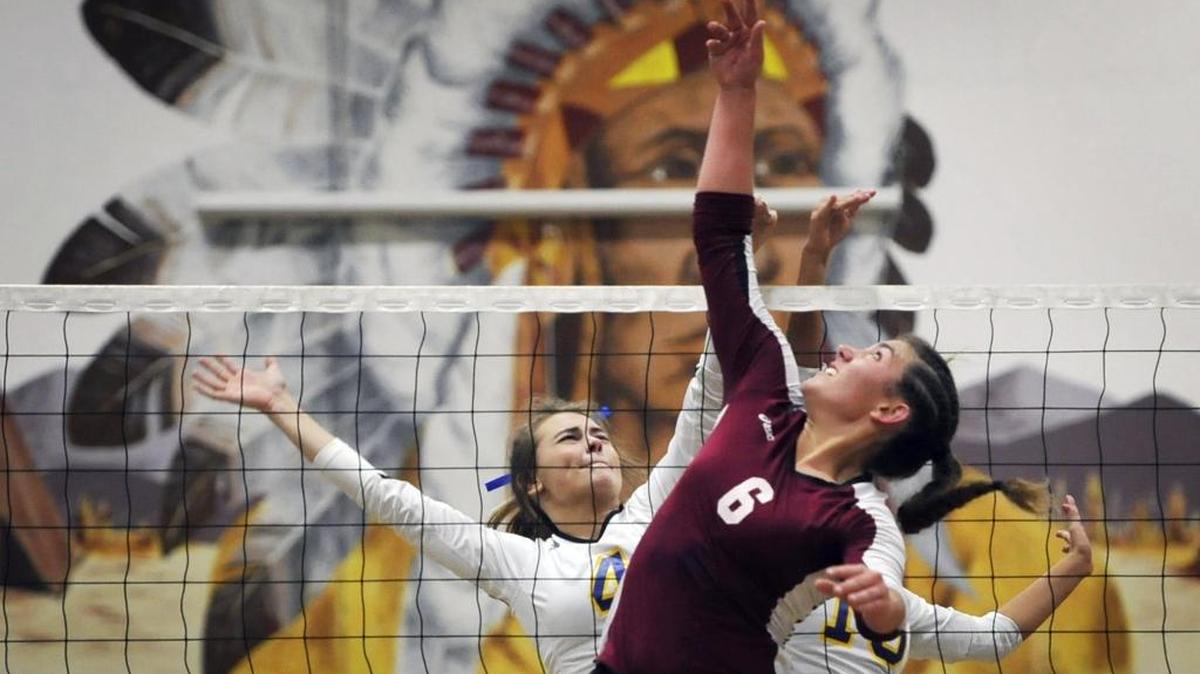 Sierra High’s Kinlee Rix, right, delivers a point against the defense Dos Palos’ Taryn Vincent and Alex Romero in the Central Section Division IV girls volleyball semifinals Tuesday night. Sierra High won to advance to Saturday’s final against Minarets.
