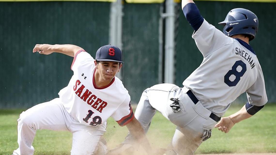 Bullard’s Nick Sheehan, right, beats the throw to third base covered by Sanger Jordan Paz, left, Tuesday, May 3, 2016 in Sanger, Calif. The Knights won 8-1 to clinch the CMAC title.