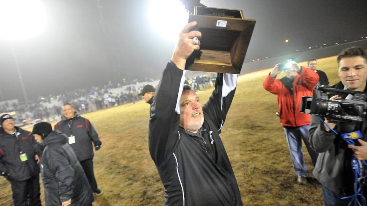 Hanford coach Josh Young shows off the prize Saturday.