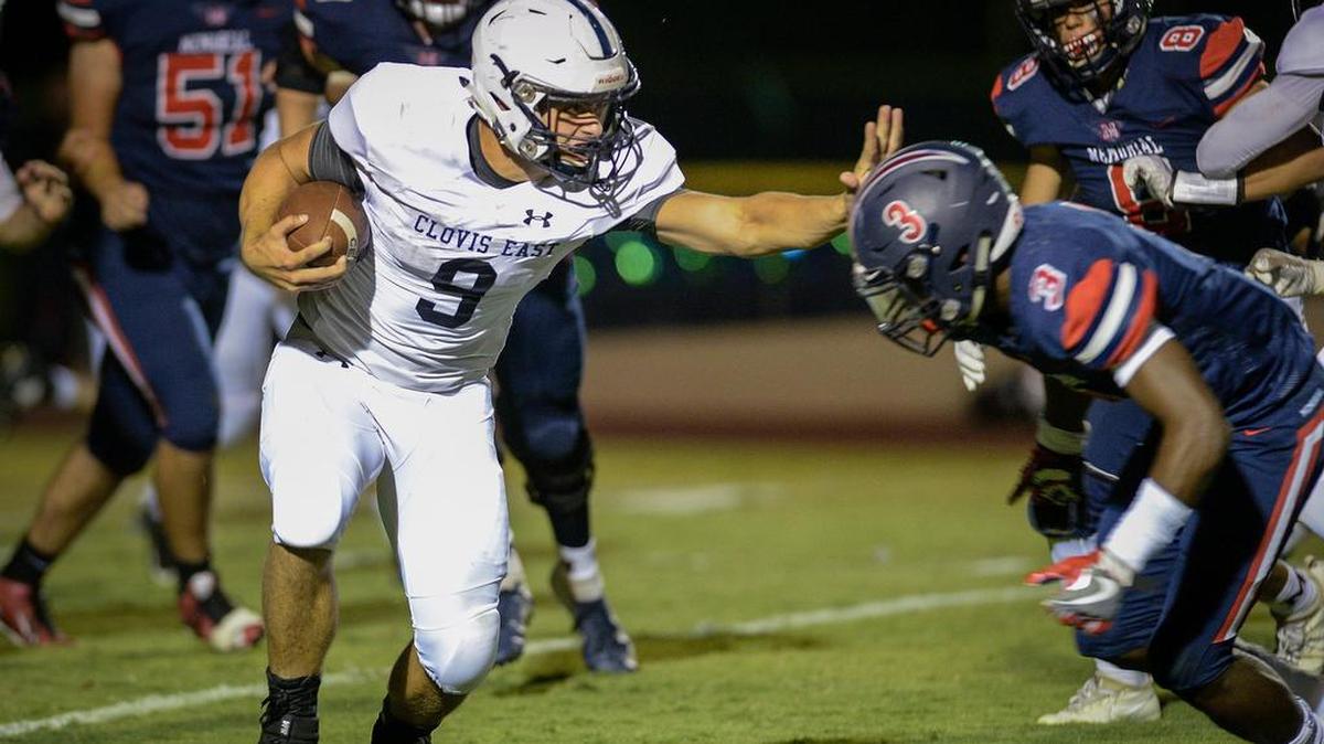 Clovis East’s Ryan Hunt tries to stiff-arm his way past Leonard Glass and the Memorial defense during their game Sept. 14.