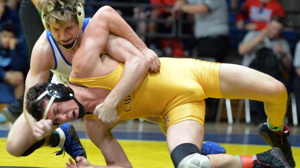 Clovis High’s Brandon Martino, top, duels Clovis West’s Chris Lane in the 152-pound championship match of Saturday’s Yosemite Divisionals. Martino won the individual title 3-1, though his five-time defending state champion Cougars had to settle for second in the team standings behind Buchanan.