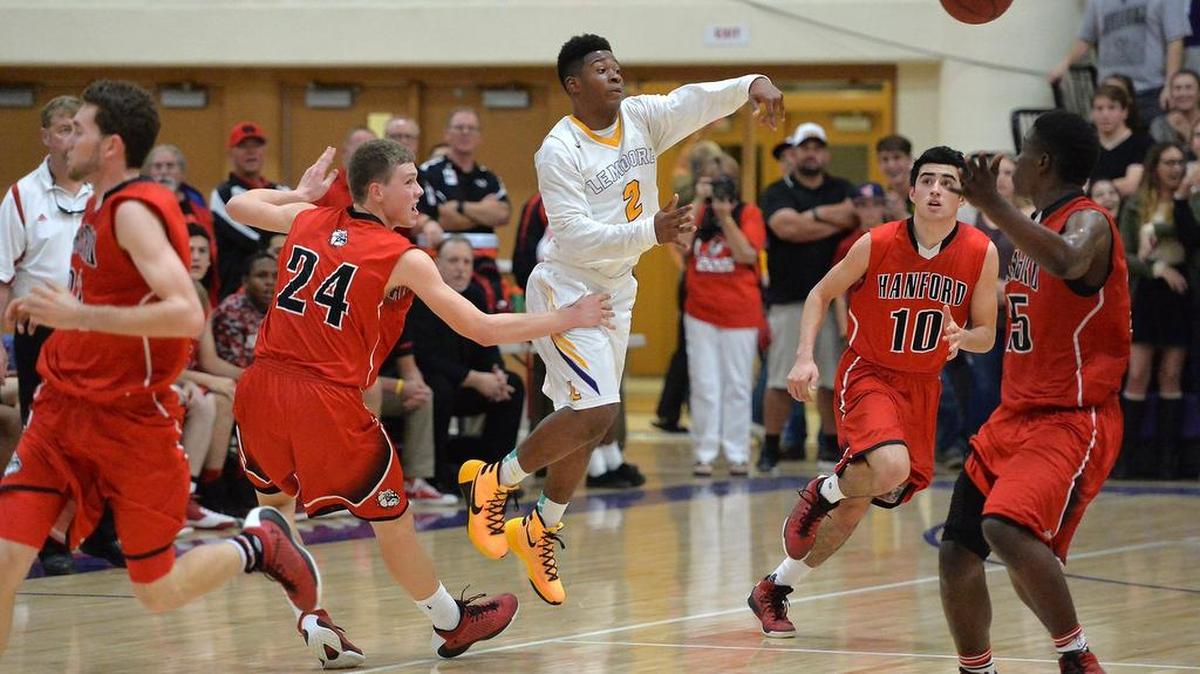 Lemoore’s Reggie Davis, center, passes the ball over Hanford’s defense in the Central Section Division II quarterfinals on Thursday, February 25, 2016, at Lemoore High School in Lemoore.