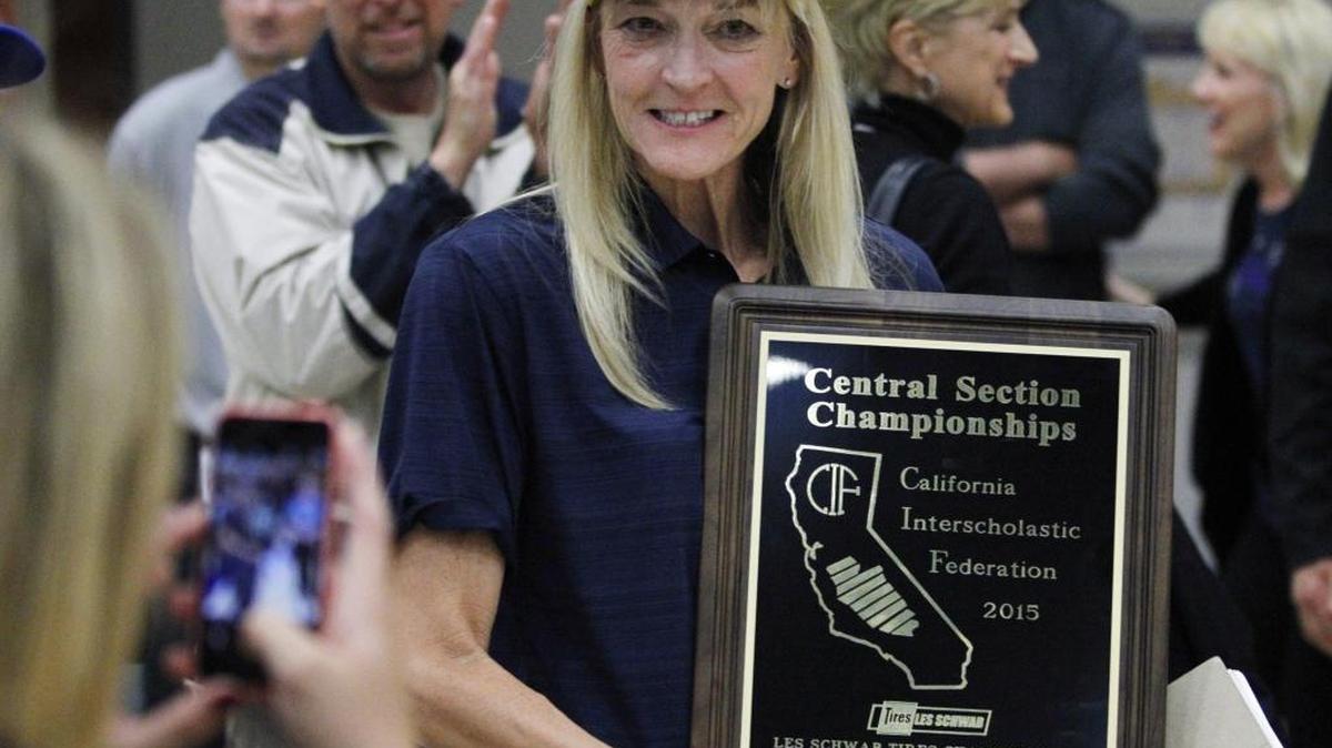 Clovis East High coach Vicki Samarin displays the trophy after the Timberwolves captured the Central Section Division I girls volleyball title in 2015. It was the program’s first section title. Mrs. Samarin died April 1, 2017, at age 56.