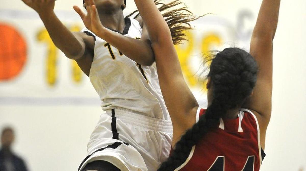 Edison High’s Jerrene Carter slips past Sanger’s Heavenly Lealoff to score in Wednesday night’s County/Metro Athletic Conference game. Carter scored 18 points as Tigers, ranked second by The Bee in the Central Section, picked up a 52-47 win.