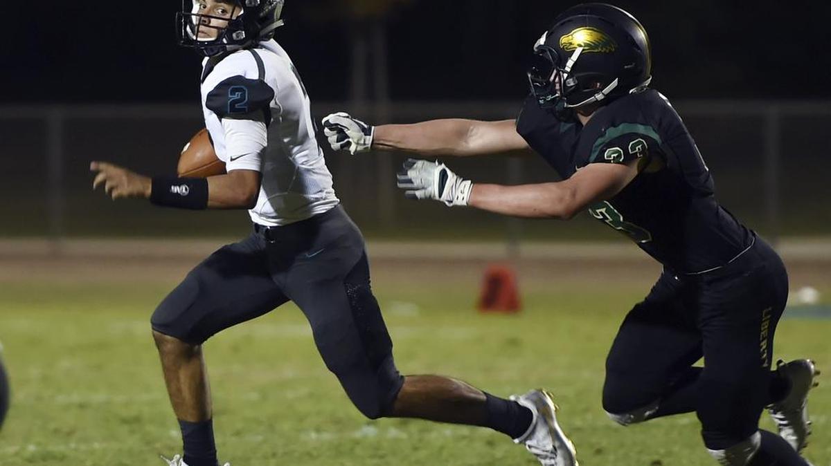 Mendota's Junior Cardenas, shown scrambling from Liberty-Madera Ranchos’ Wyatt Roth on Sept. 2, 2016, will lead the Aztecs at home against Firebaugh on Friday, Oct. 14, 2016, in a duel of top-ranked and unbeaten Division V teams.