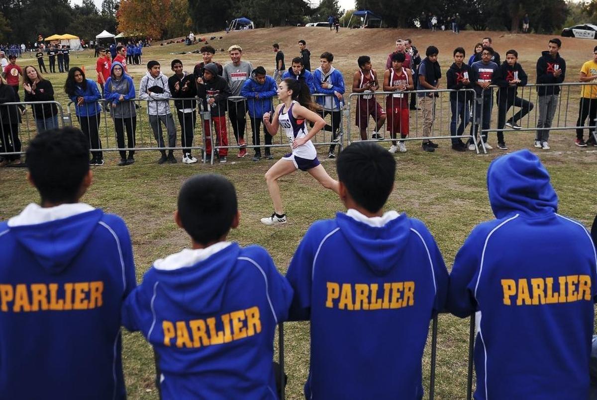 Parlier High runners watch as Washington’s Caliska Avila wins the Division V race at the CIF Central Section Cross Country Championships on Thursday, Nov. 16, 2017, at Woodward Park. Avila was timed in 21:03, with Memorial’s Marianne Gleason second in 21:43 and Chowchilla’s Paulina Granados third in 21.49.