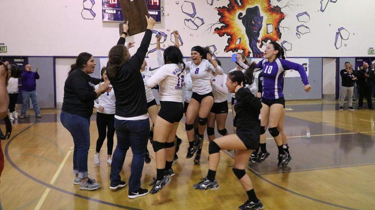 Washington Union High volleyball coach Allison Hetherington brings the Northern California Regional Division V championship plaque to her celebrating team Tuesday night, Nov. 13 in Easton.