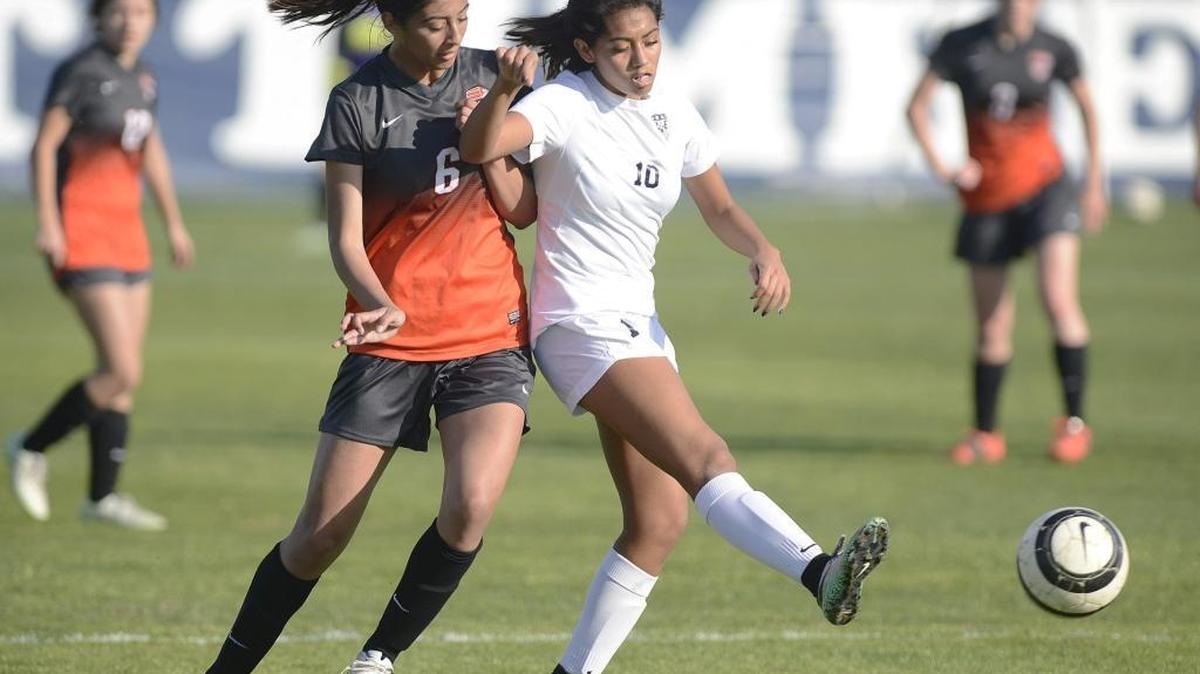 Clovis East High’s Mia Castillo, right, kicks the ball away from Central’s Ali Aroz in a Central Section Division I quarterfinal Friday. Castillo and Catalina Villegas combined for the go-ahead goal in overtime as the top-seeded Timberwolves beat the No. 9 Grizzlies 4-2 to advance to next week’s semifinal against No. 4 Frontier or No. 5 Liberty-Bakersfield.
