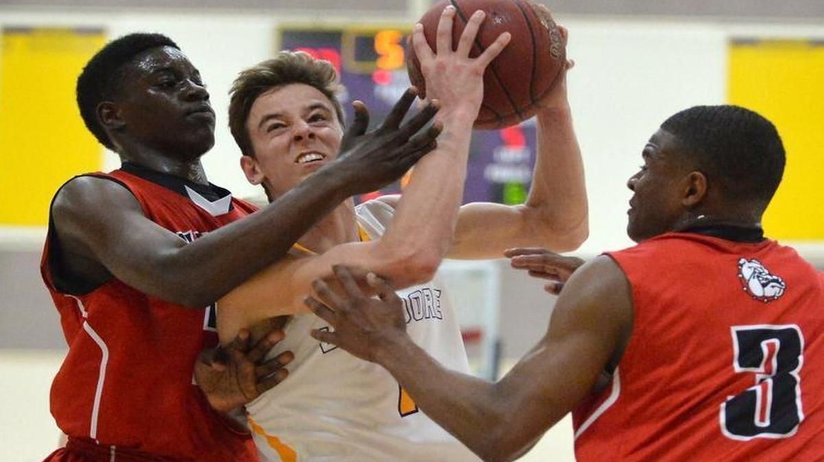 Lemoore’s Spencer Stinger fights through the defense of Hanford’s Jayshaun Collins, left, and Ju’Wuane Hughes in the Central Section Division II boys basketball quarterfinals on Thursday, Feb. 25, 2016 at Lemoore. Second-seeded Lemoore beat No. 7 Hanford 71-67 before a crowd of 2,700 and next faces No. 3 Memorial in the semifinals.