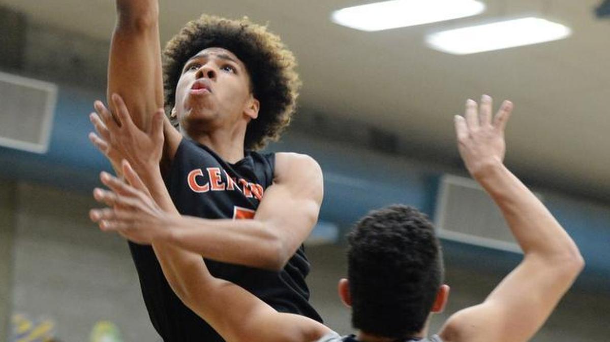 Central’s Cam’Ron Wilson, left, goes to the hoop during a regular-season game against Clovis East.