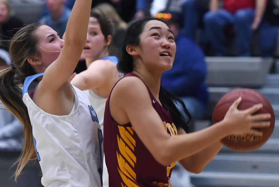 Clovis West’s Nikki Tom, right, blocked by Clovis North’s Taylor Pacheco, left, in a TRAC doubleheader matchup Friday, Jan. 10, 2020 in Clovis.
