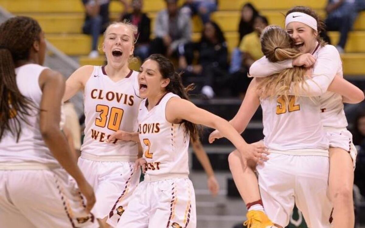 Sarah Bates hugs Tess Amundsen while Megan Anderson (30) and Danae Marquez (2) get ready to whoop it up with teammates after Clovis West beat Long Beach Poly 53-44 in the CIF Southern California Regional Open Division girls basketball final Saturday, March 18.