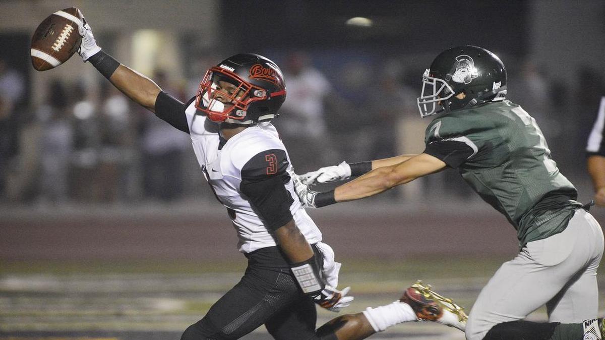 
Hanford High’s Juwuane Hughes celebrates after hauling in a touchdown catch as Dinuba’s Daniel Guzman closes in during the teams’ Sept. 11, 2015 game in Dinuba.
