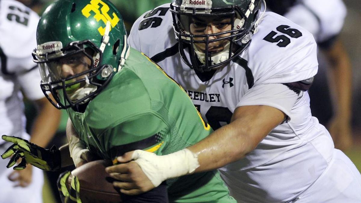 
Reedley High’s Ricky Garcia takes down Roosevelt’s Leo Leal during first-half action of the teams’ North Yosemite League opener Oct. 8, 2015. Garcia and the Tigers picked up their first win of the season with a 42-19 victory.
