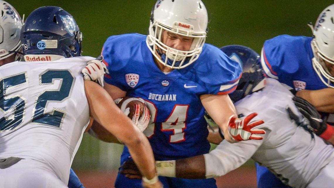 Buchanan’s Caden Rodgers, center, tries to bust through the Bullard defense during their game at Veterans Memorial Stadium in Clovis on Friday, Aug. 30, 2019.