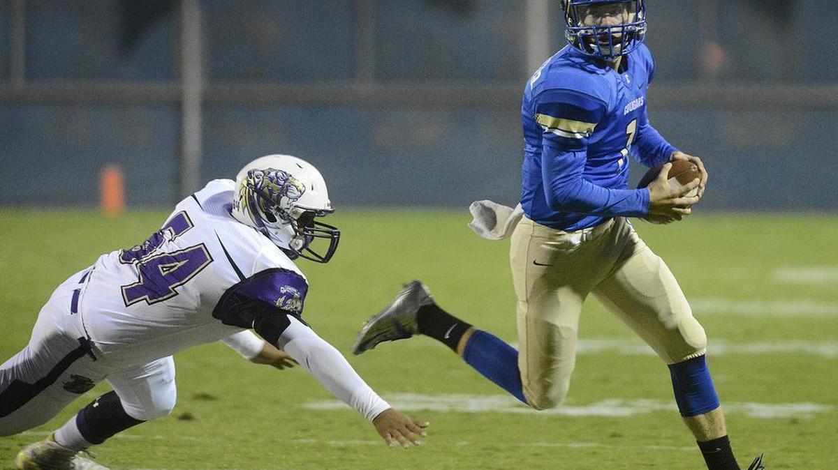 
Clovis quarterback Sean Kuenzinger, right, evades a tackle attempt by Lemoore’s Cedrik Vasquez during the first quarter of their game at Lamonica Stadium in Clovis, Friday, Sept. 4, 2015.
