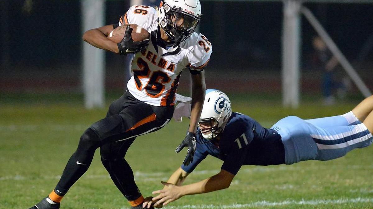 Selma’s Tiveon Stroud, left, carries the ball past Central Valley Christian’s Scott Vanderwall in a Central Sequoia League game at Central Valley Christian on Oct. 31, 2015 in Visalia, California.