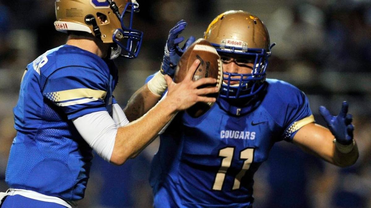 Clovis High quarterback Sean Kuenzinger hands off to Josh Hokit in the first half of Friday’s Tri-River Athletic Conference game against Buchanan. Hokit rushed for two touchdowns and the Central Section No. 4-ranked Cougars totaled 176 yards on the ground in their 34-13 win over the No. 6 Bears.
