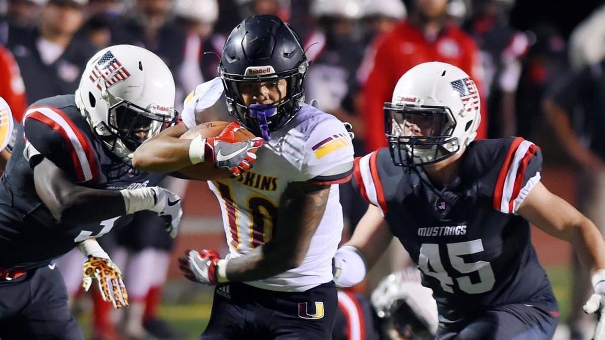Tulare Union running back Kazmeir Allen, center, is pursued by Tulare Western's Marlon Benson, left, and Tyler Loscutova, right, in first half Bell Game action Friday night, Oct. 3, 2017 in Tulare. Tulare Union led 35-14 at halftime.