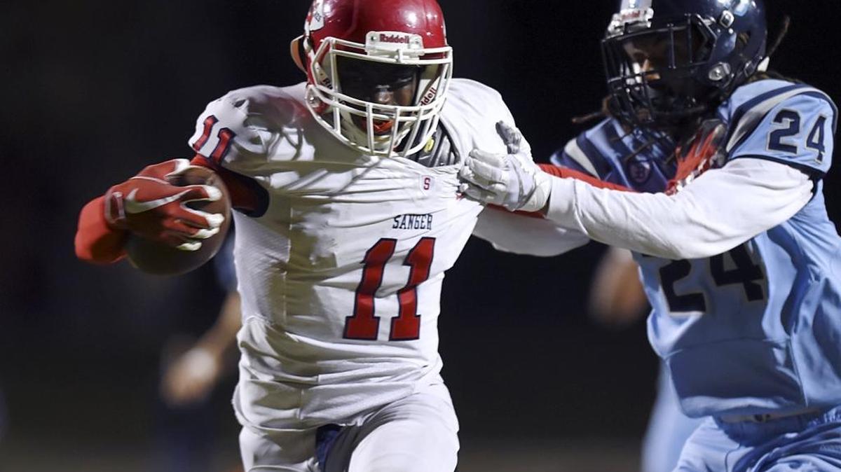 Sanger High’s Morice Norris breaks free from Bullard’s Corey Scott to score a touchdown in a Central Section Division I playoff game Thursday, Nov. 9, 2017.