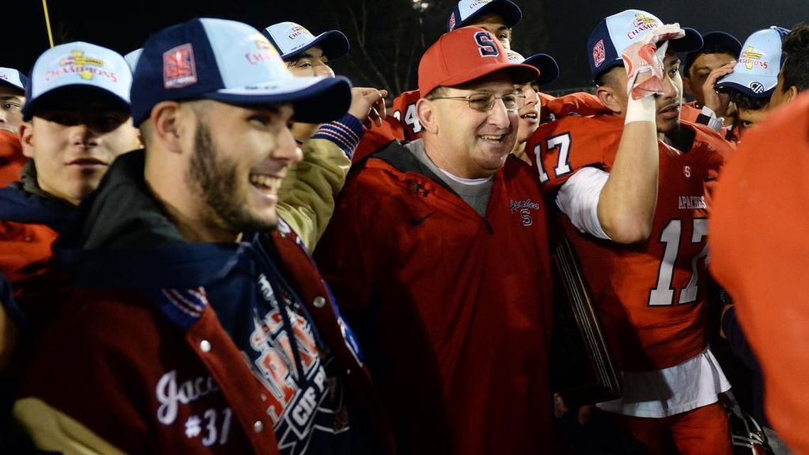 Sanger coach Chuck Shidan celebrates with players after beating Ridgeview 20-10 for the Central Section Division-II championship at Sanger Friday, Dec. 2, 2016. Shidan has announced he is stepping down as Apaches coach after 27 years.