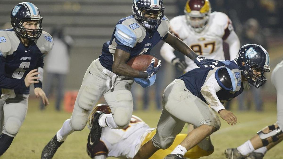 Bullard High’s Charles Williams looks for room behind a block by Josue Gutierrez in the first half of a quarterfinal playoff game against Clovis West on Friday at McLane Stadium.
