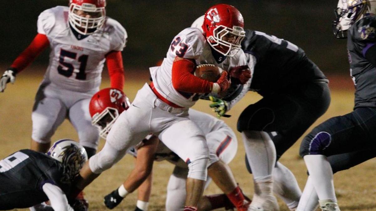 Sanger High’s Andrew Azua tries to find his way through a stout Lemoore defense that includes Rigoberto Carillo in Friday’s Central Section Division II semifinal.