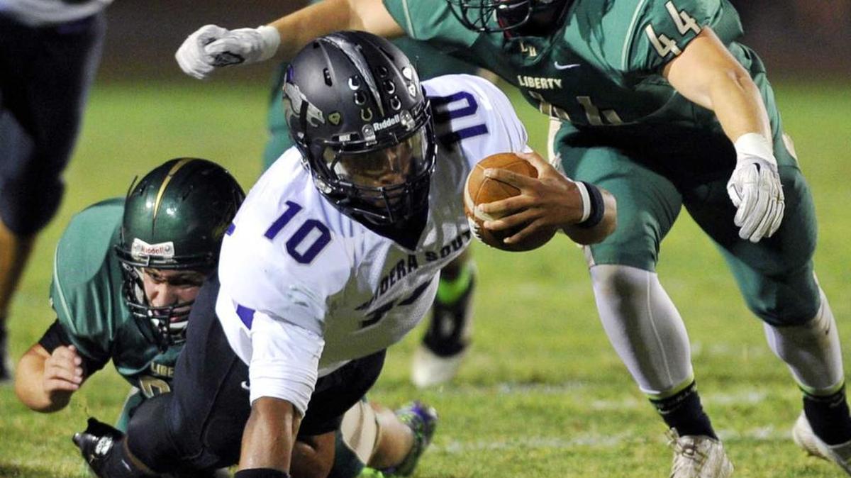 
Madera South quarterback Jonah Johnson, center, fights for extra yardage has he’s brought down by Liberty-Madera in first half action Friday, October 2, 2015 at Madera Ranchos. Madera South won 41-21 to snap Liberty’s 22-game winning streak.
