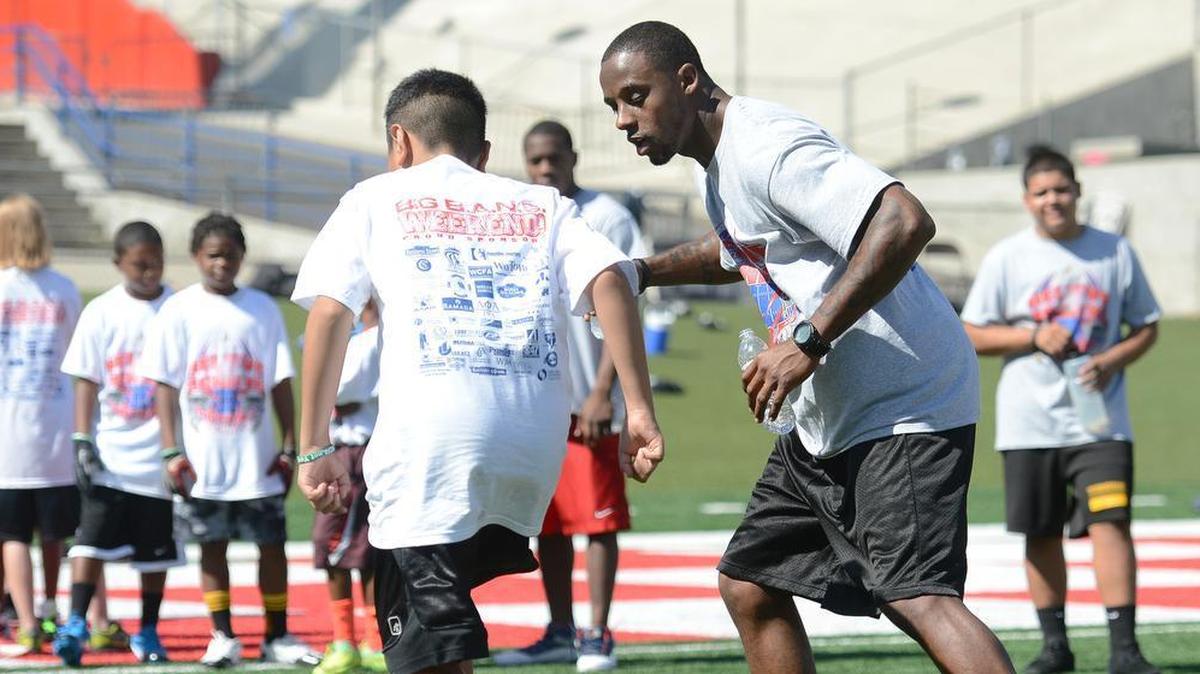 Former NFL player Atnaf Harris, right, was removed as coach at Edison High on Friday. Details why were not immediately given. Edison is 2-4 on the season and just kicked off County/Metro Athletic Conference play with a 40-23 win against Madera South on Thursday.