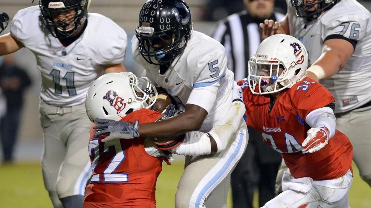 David Akande of Central Section fourth-ranked Clovis North runs over and past Buchanan’s Braylen Williams (22) and Carlos Ayala for a touchdown in the first half of Friday’s game at Veterans Memorial Stadium. Buchanan rallied for a 31-28 victory to earn the Central Section seventh-ranked Bears a share of the Tri-River Athletic Conference title ahead of Saturday’s announcement of playoff seedings across six section 11-man divisions.