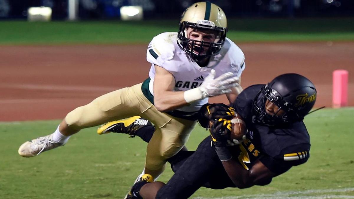 Edison’s Steve Stephens, right, intercepts a pass intended for Garces’ Scott Boylan, left, in a game held at Sunnyside High in Fresno on Friday, Sept. 30, 2016.
