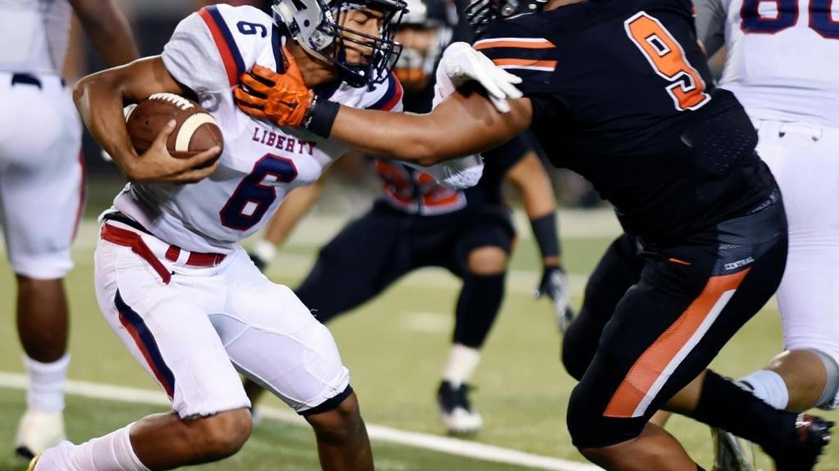 Liberty High quarterback Isaiah Hill is sacked by Central's Justin Henry on Friday, Sept. 8, 2017. Top-ranked Central trounced No. 3 Liberty 30-3.