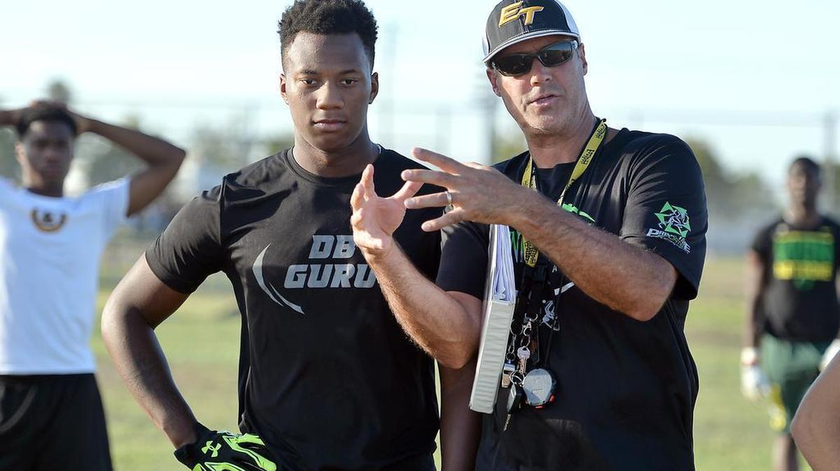 
Edison High linebacker/tight end David Tate, left, talks with coach Matt Johnson during Monday’s opening fall practice.

