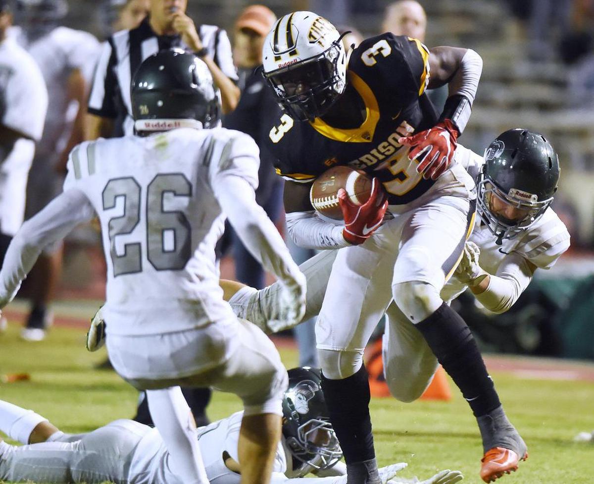 Edison’s Velltray Jefferson spins free from Dinuba’s Justin Gonzalez, right, in a September 2019 game.