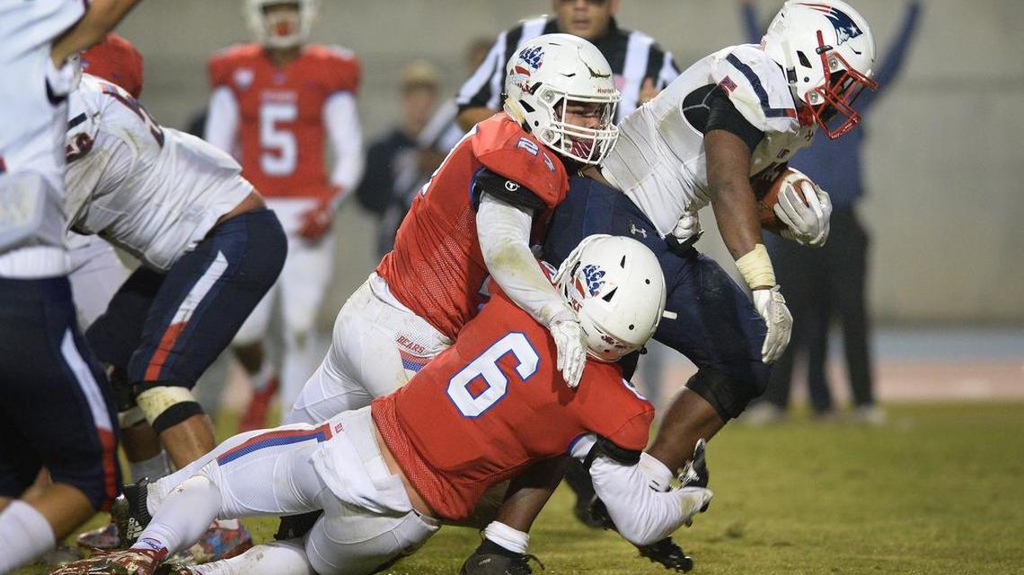 Liberty-Bakersfield’s Sam Stewart Jr. pulls Buchanan’s Michael Mertens, left, and Tanner Blount over the goal line for a rushing touchdown in the first half.