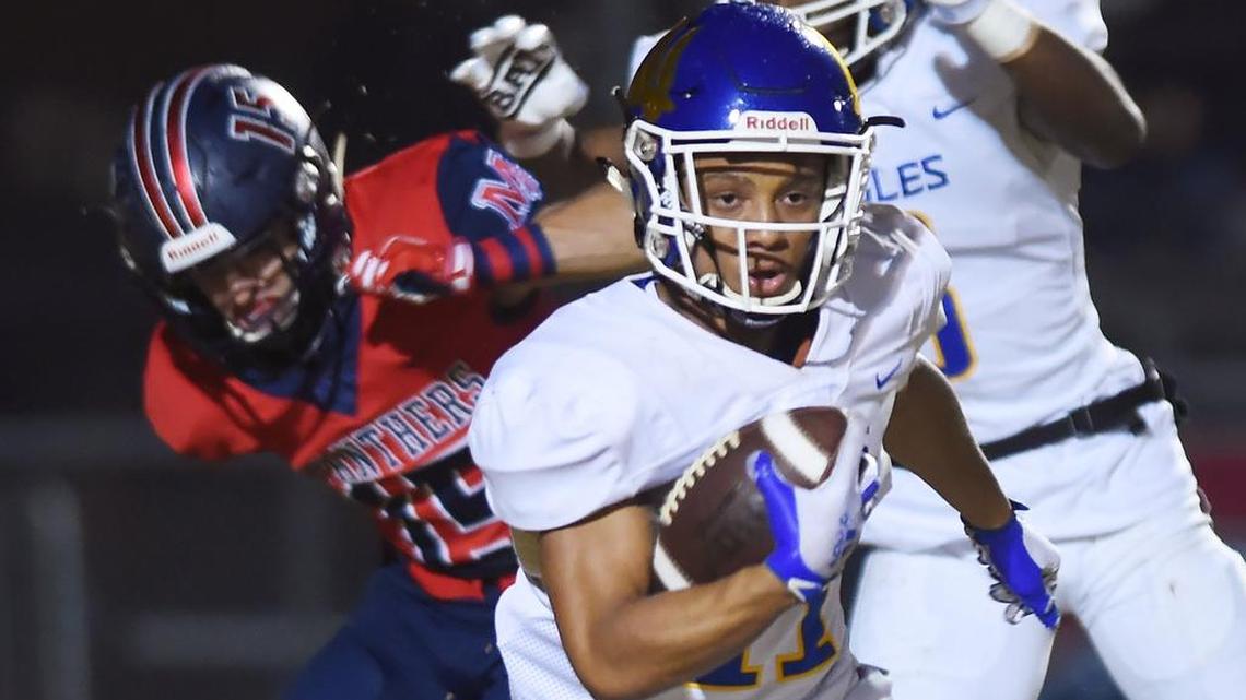 Bakersfield Christian’s Alex Wallace III, center, runs for yardage after intercepting a pass intended forSan Joaquin Memorial’s Mac Dalena, left, in first quarter action of the Central Section D-III championship game Friday, Nov. 23, 2018 in Fresno.
