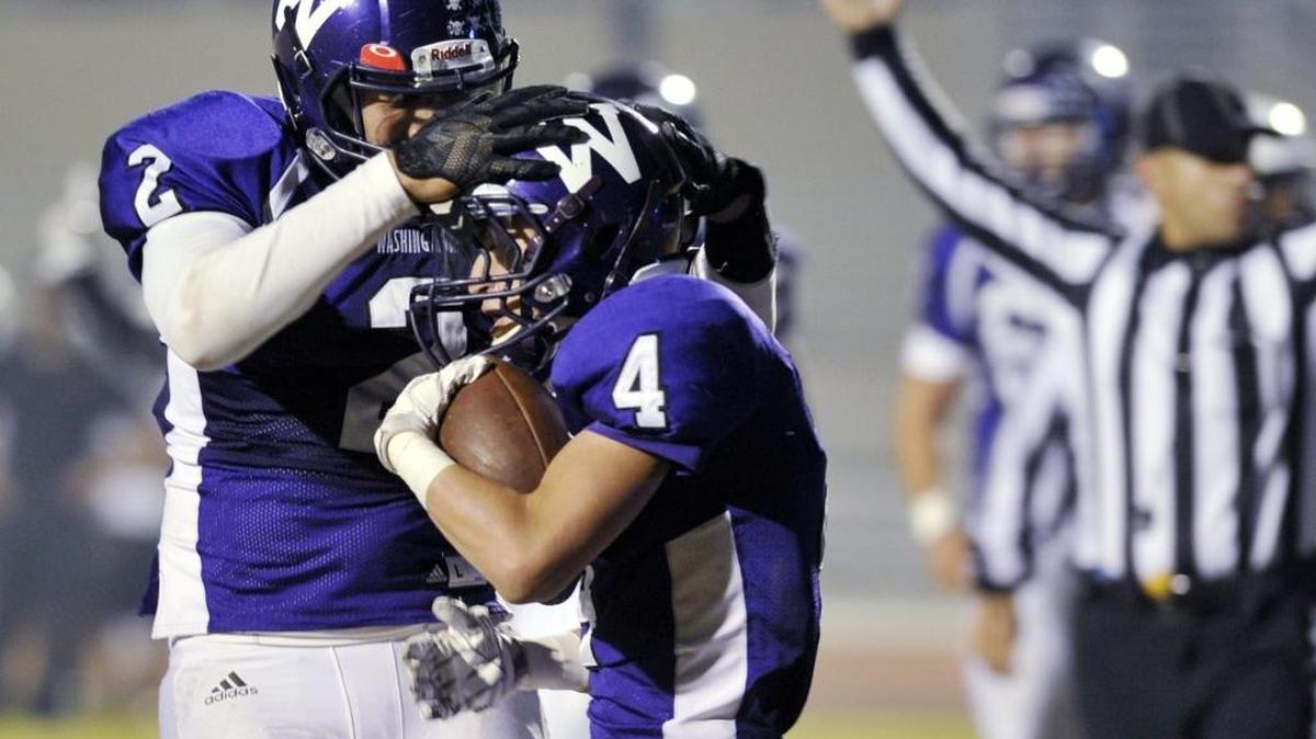 Washington High’s Alex Bolden, left, celebrates with Adam Martinez after Martinez’s touchdown in a Central Section Division IV quarterfinal Friday. Washington won 31-14 to advance to a semifinal at second-seeded Chavez.