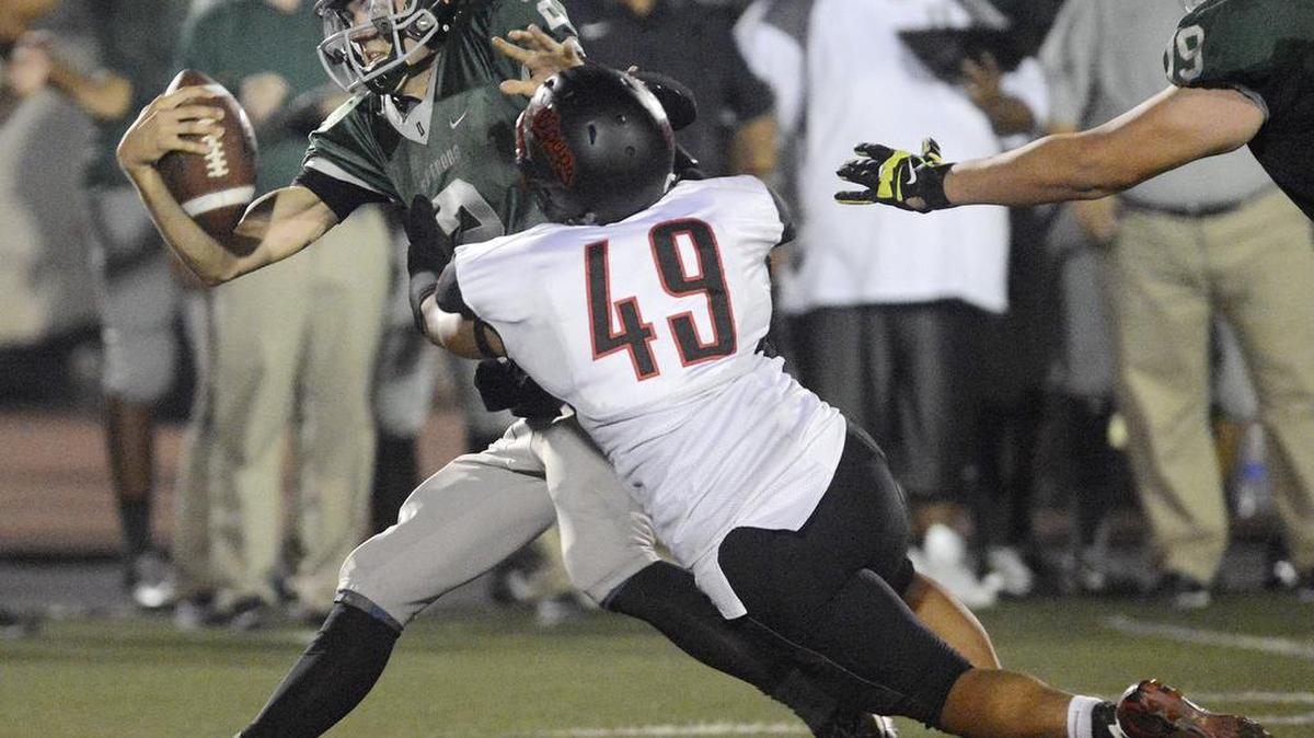 
Dinuba quarterback Isaac Leppke is sacked by Hanford’s Ellix Jimmeye in their game at Dinuba High Friday, Sept. 11, 2015.
