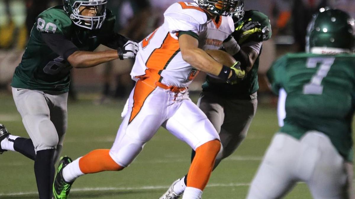 Porterville High’s Isaiah Jones, chased by Dinuba defenders in this September 2013 photo, duels with Tulare’s Romello Harris for the final time Friday night.