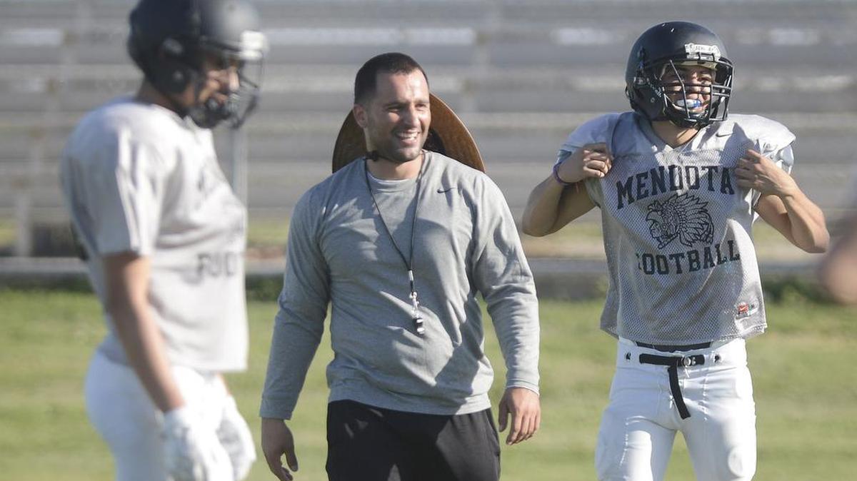 
Mendota High football coach Beto Mejia works with the Aztecs players during practice on Aug. 12, 2015. Mejia was suspended as coach last fall after he was charged with insurance fraud but has been reinstated by the school district while the case works through the court system.
