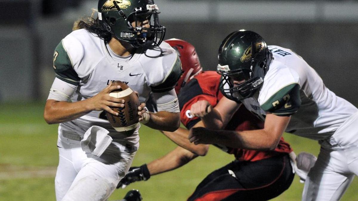 
Liberty-Madera Ranchos’ Markie Brandt, left, rolls out to pass against Fowler in a matchup Friday, September 18, 2015 in Fowler, Calif.
