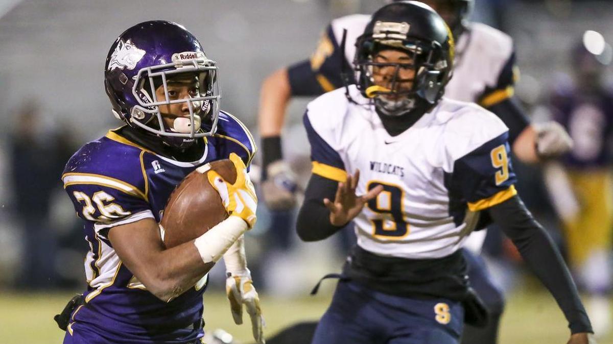 Ridgeview’s Darius Smith carries the ball past Sunnyside’s Aaron Mouton during the first half Friday night at Ridgeview High. Ridgeview beat Sunnyside 56-16.