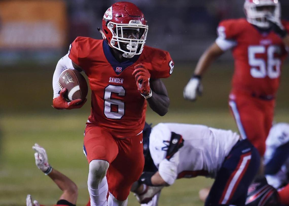 Sanger’s Kosi Agina, center, runs down the sidelines for a touchdown against San Joaquin Memorial Friday, Nov. 1, 2019 in Sanger.