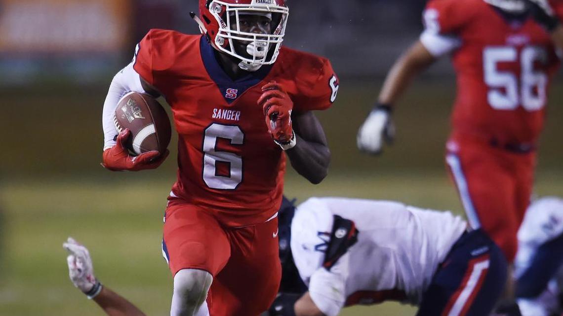 Sanger’s Kosi Agina, center, runs down the sidelines for a touchdown against San Joaquin Memorial Friday, Nov. 1, 2019 in Sanger.